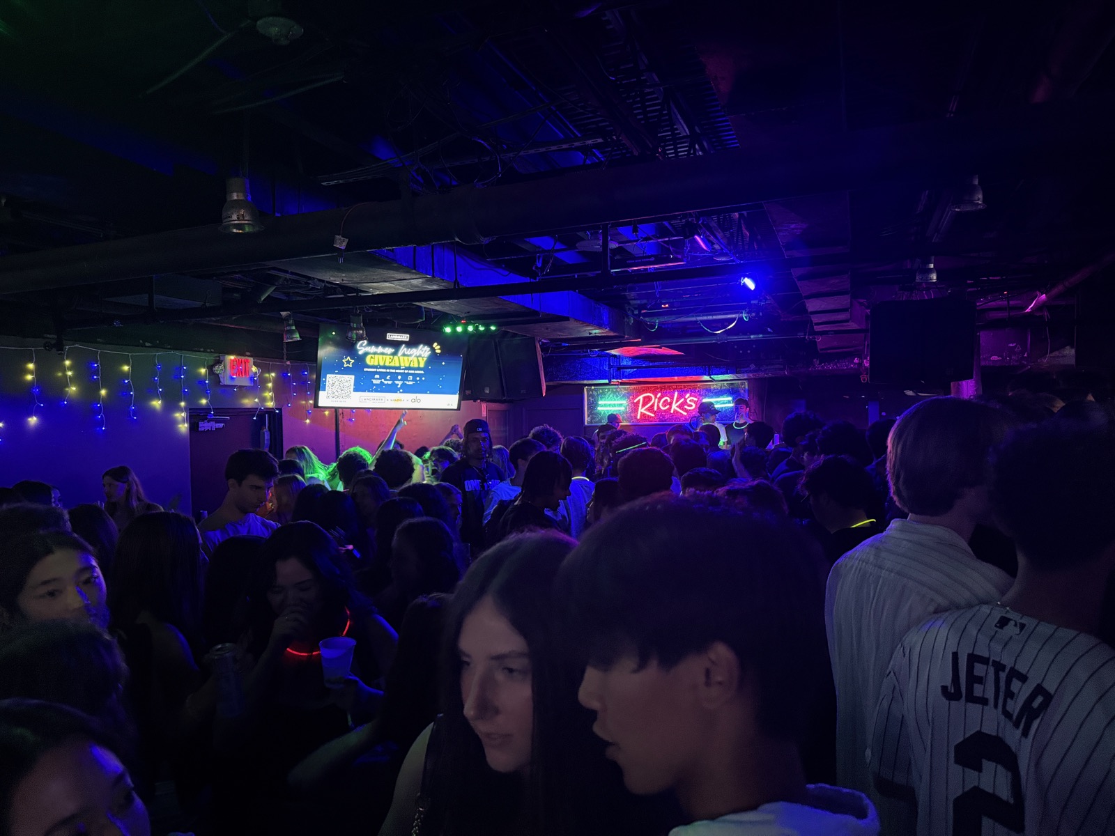 Crowded dance floor at Rick's American Café with an AdVen ad on the screen above