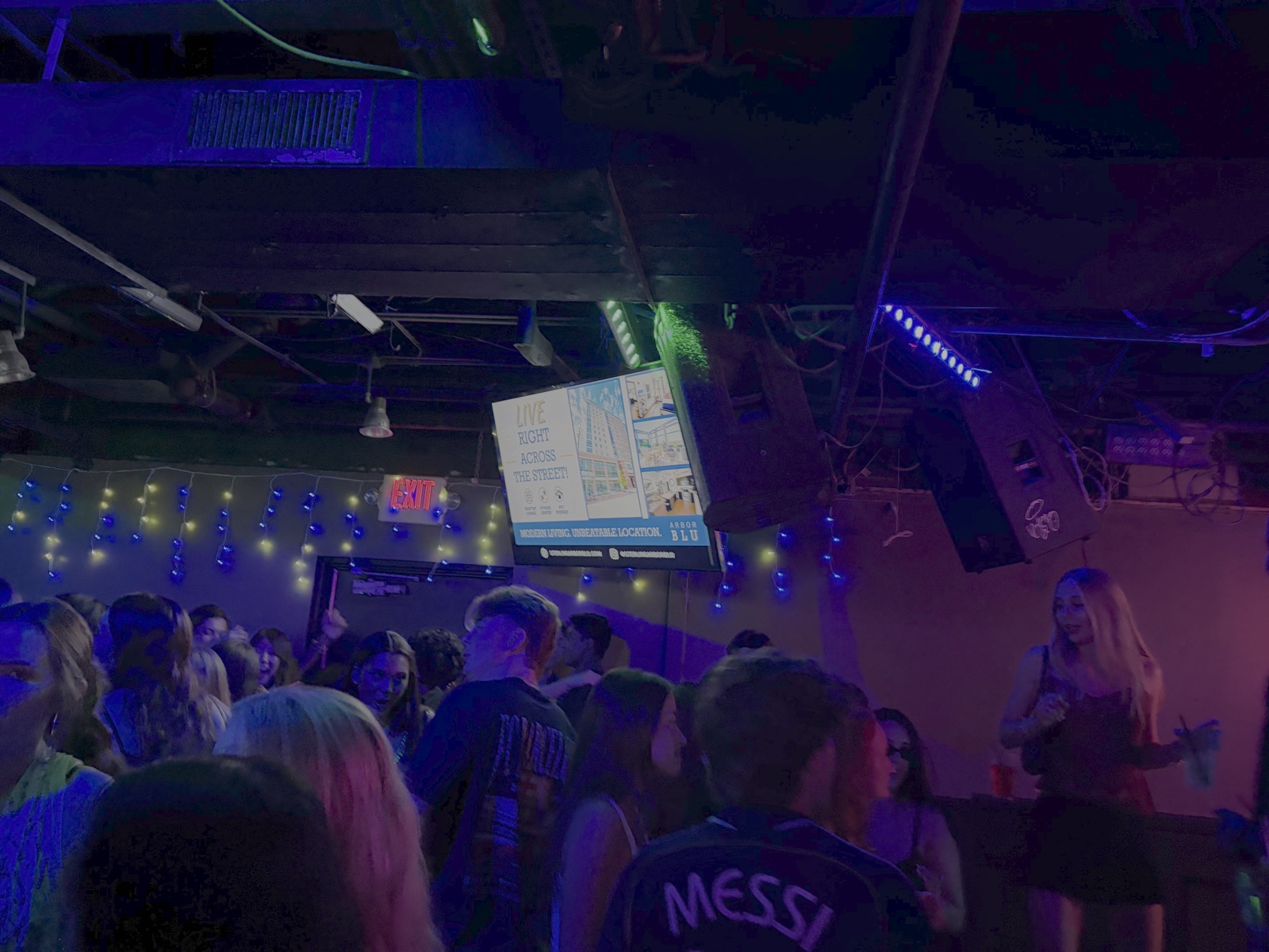 Crowd under an AdVen ad screen at Rick's American Café